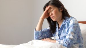 Woman with headache in bed