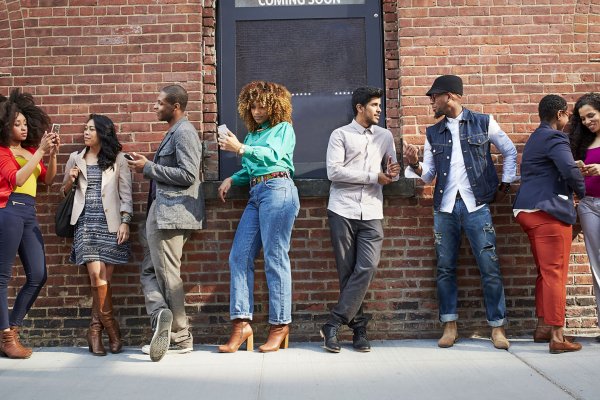 Black, Indigenous and People of Color (BIPOC) waiting in line outside of a theatre.