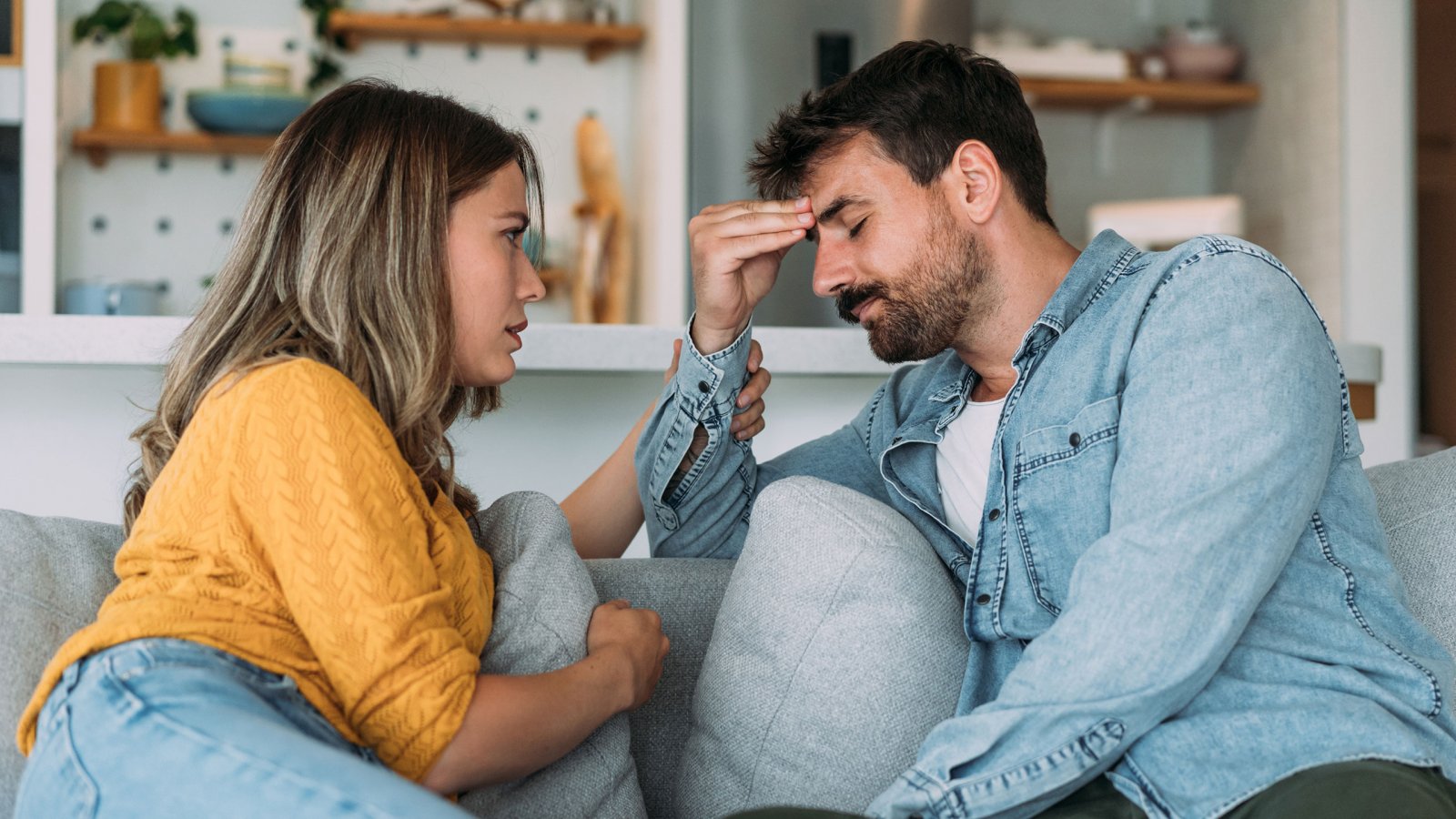 Shot of young wife expressing empathy and compassion to her sad frustrated husband.